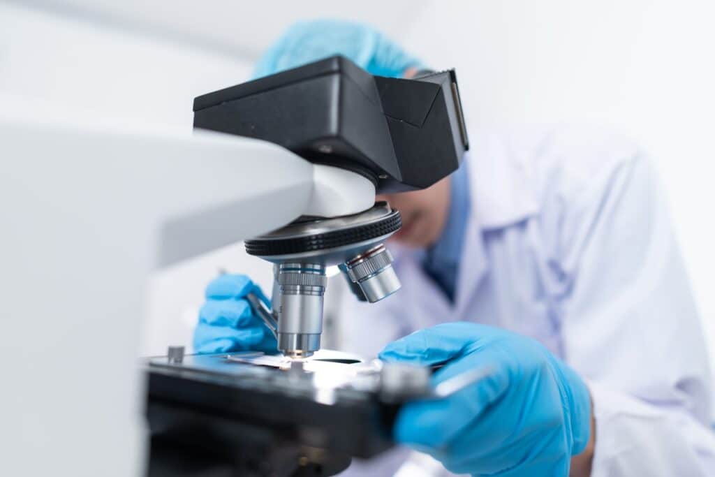 Scientist using microscope 3938022